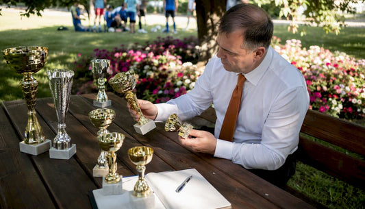 Un director de școală analizează trofeele obținute, în biroul său.